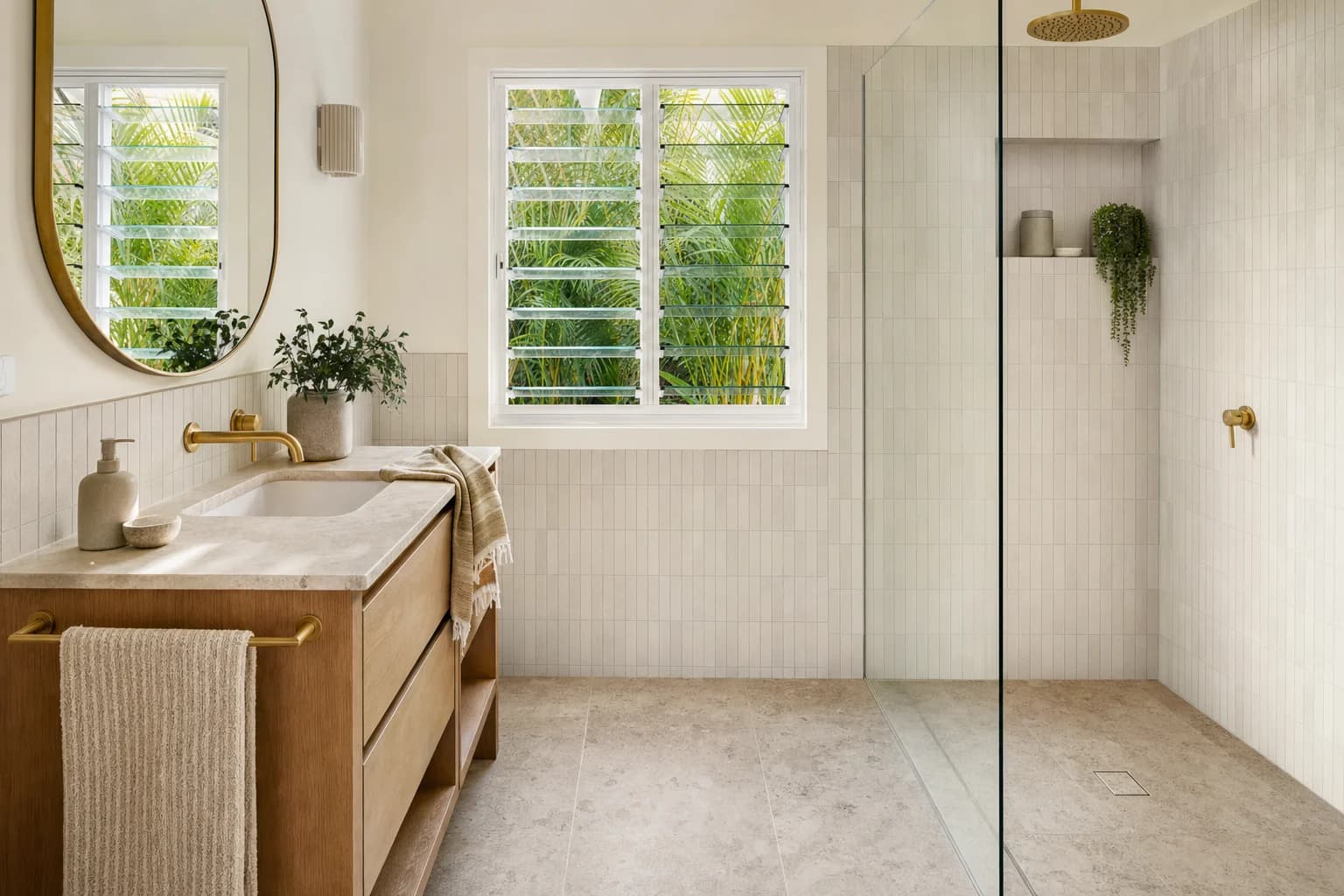 Renovated bathroom in Currumbin with warm neutral tiling, a wall-hung timber vanity with a stone top and a frameless walk-in shower